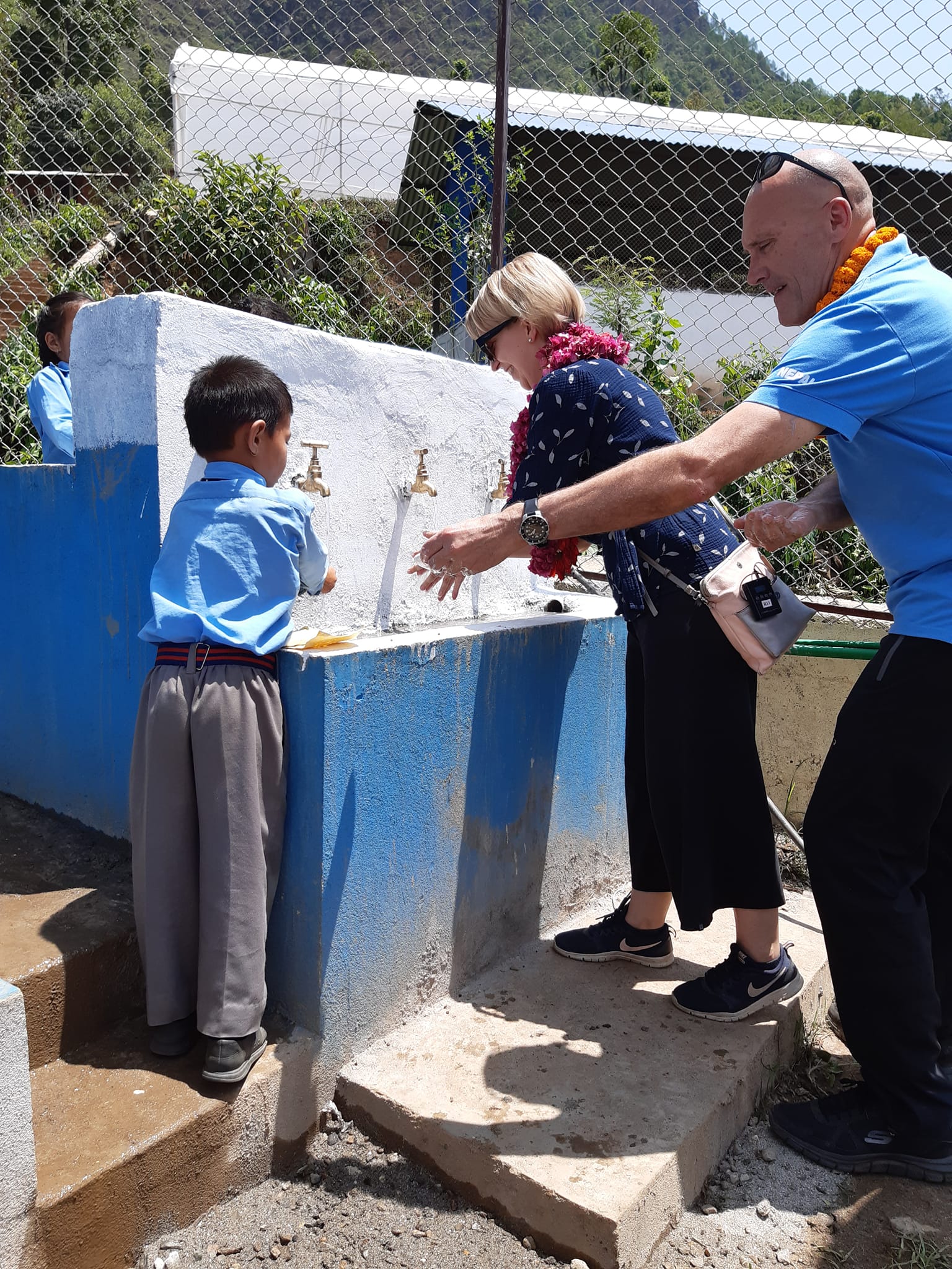 The Embassy team on a school visit with WFP related to a school-feeding program, washing hands together with the young students before the school meal.