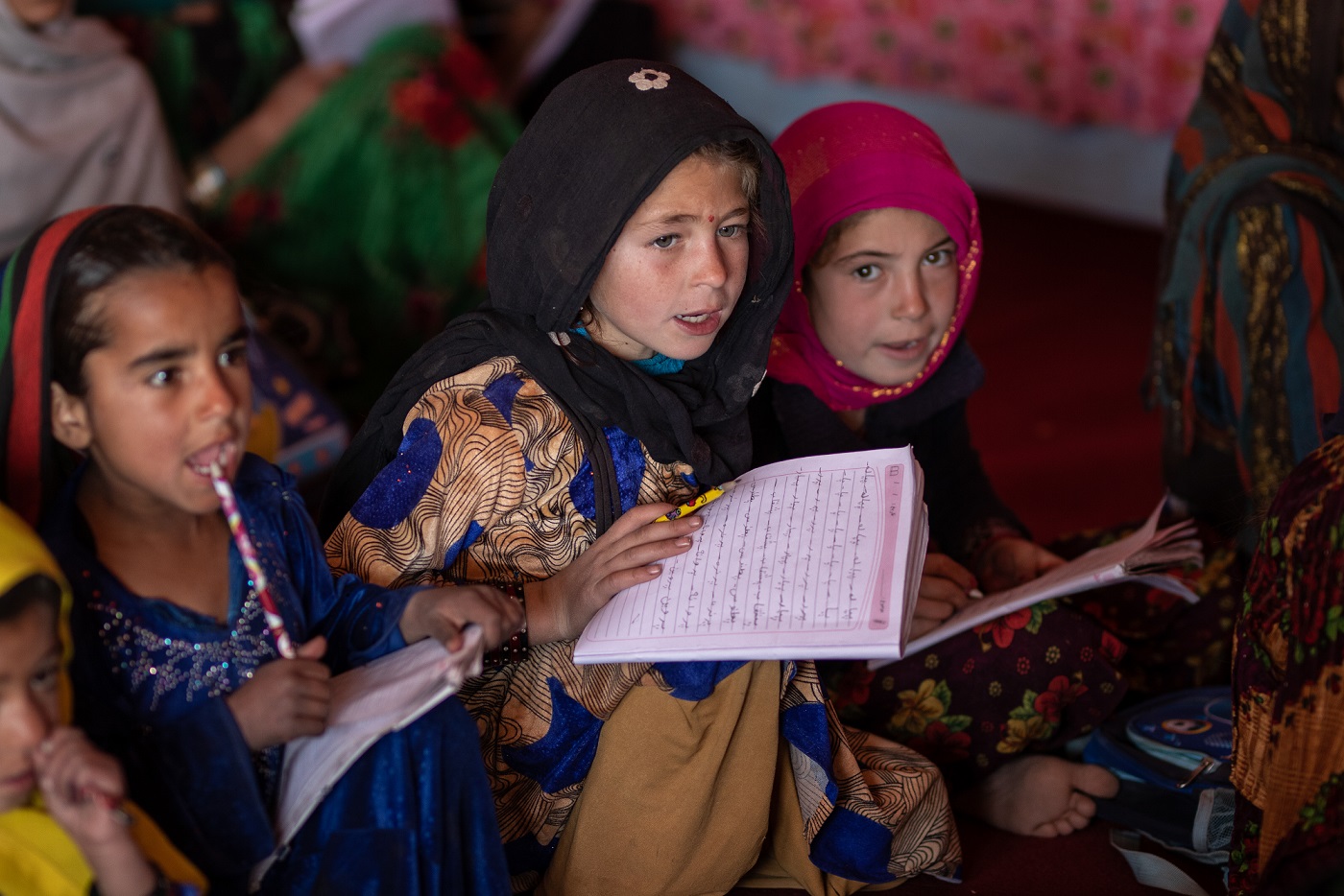 Tre afghanska flickor studerar.