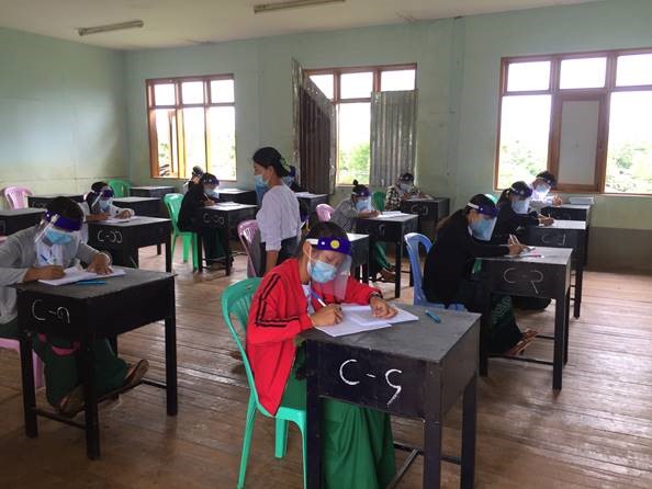 Students are sitting on their own desks and wearing masks