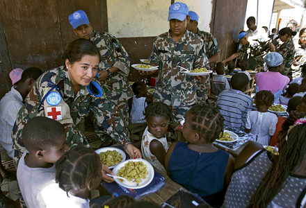 Nepalesiska fredsbevarare delar ut mat på ett barnhem i Haiti. Foto: UN Photo/Logan Abassi.