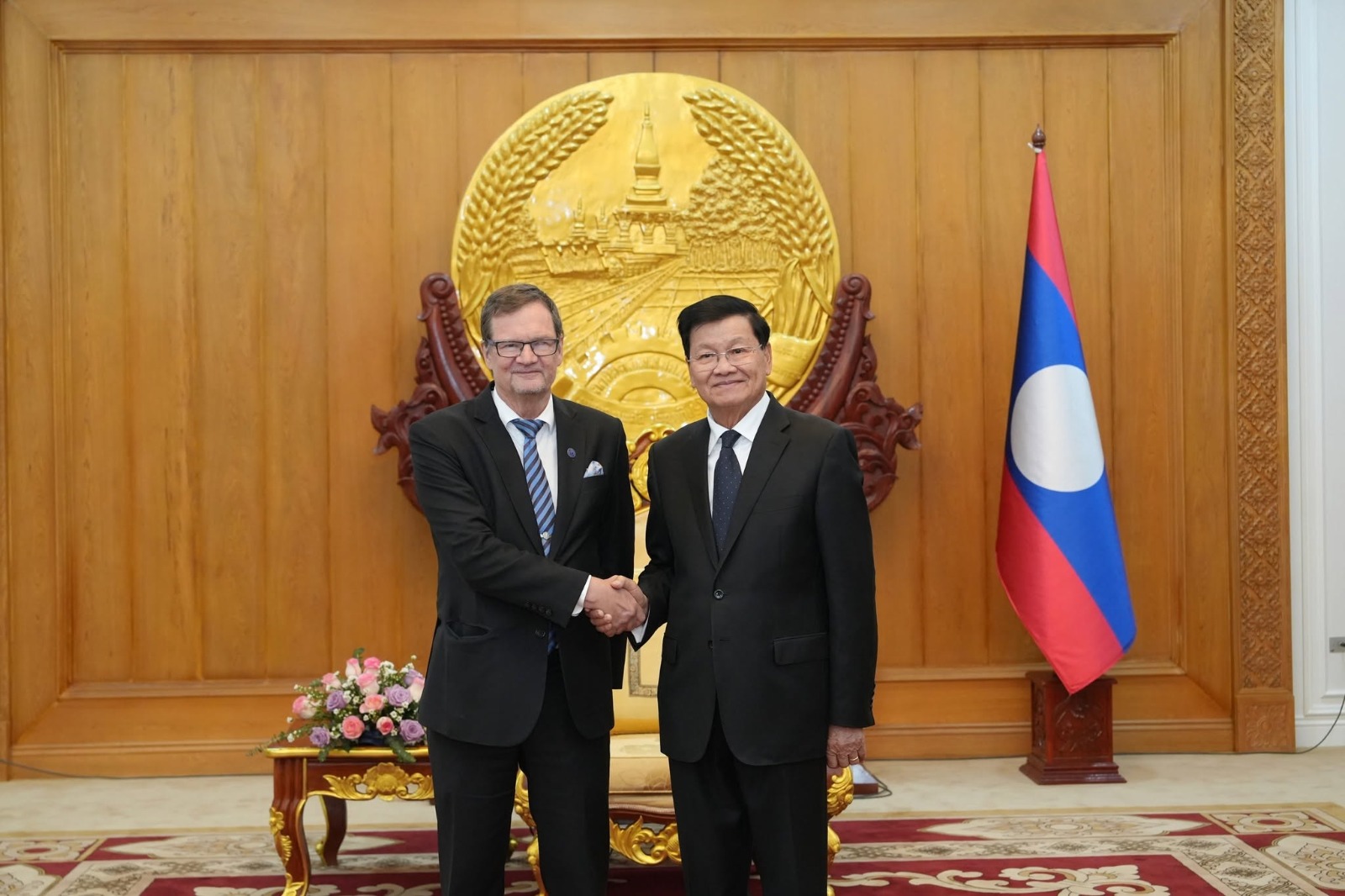 two men shaking hands, with Ambassador of Finland Pekka Voutilainen on the left and President of Lao Thongloun Sisoulith on the right
