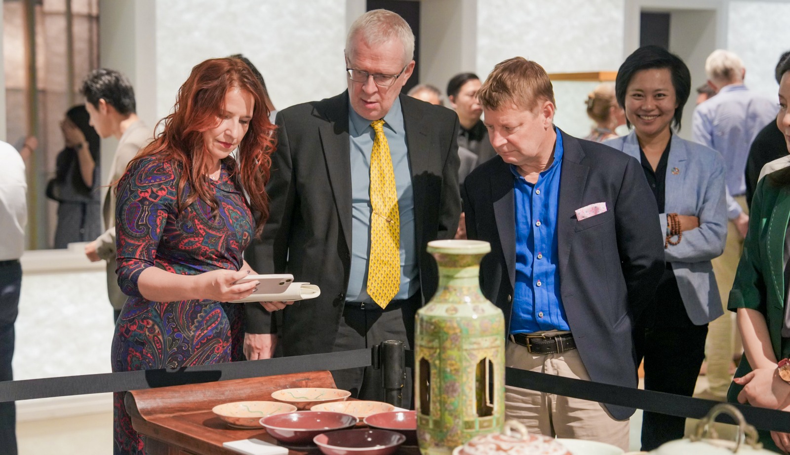 Exhibition guests marvelling a revolving floral vase from the late Qing Dynasty (19th century)