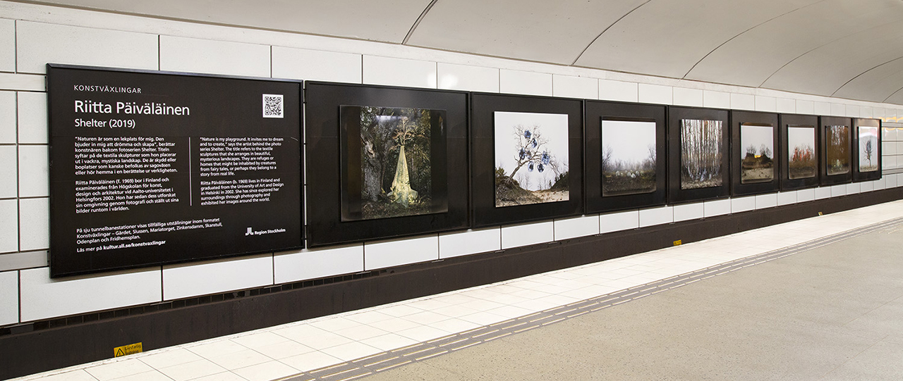 Päiväläisen valokuvia esillä metroaseman seinällä.