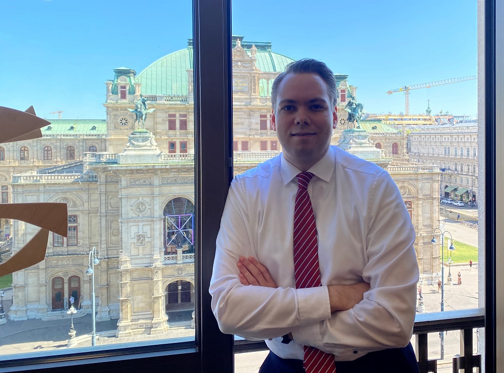 Otto Korhonen Wienin ikkunan edessä, josta näkymä Wienin valtionopperaan