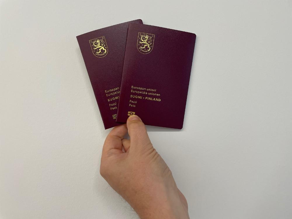 Käsi pitää kahta Suomen passia
