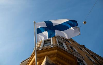 Suomen lippu liehuu vanhan asuintalon lipputangossa