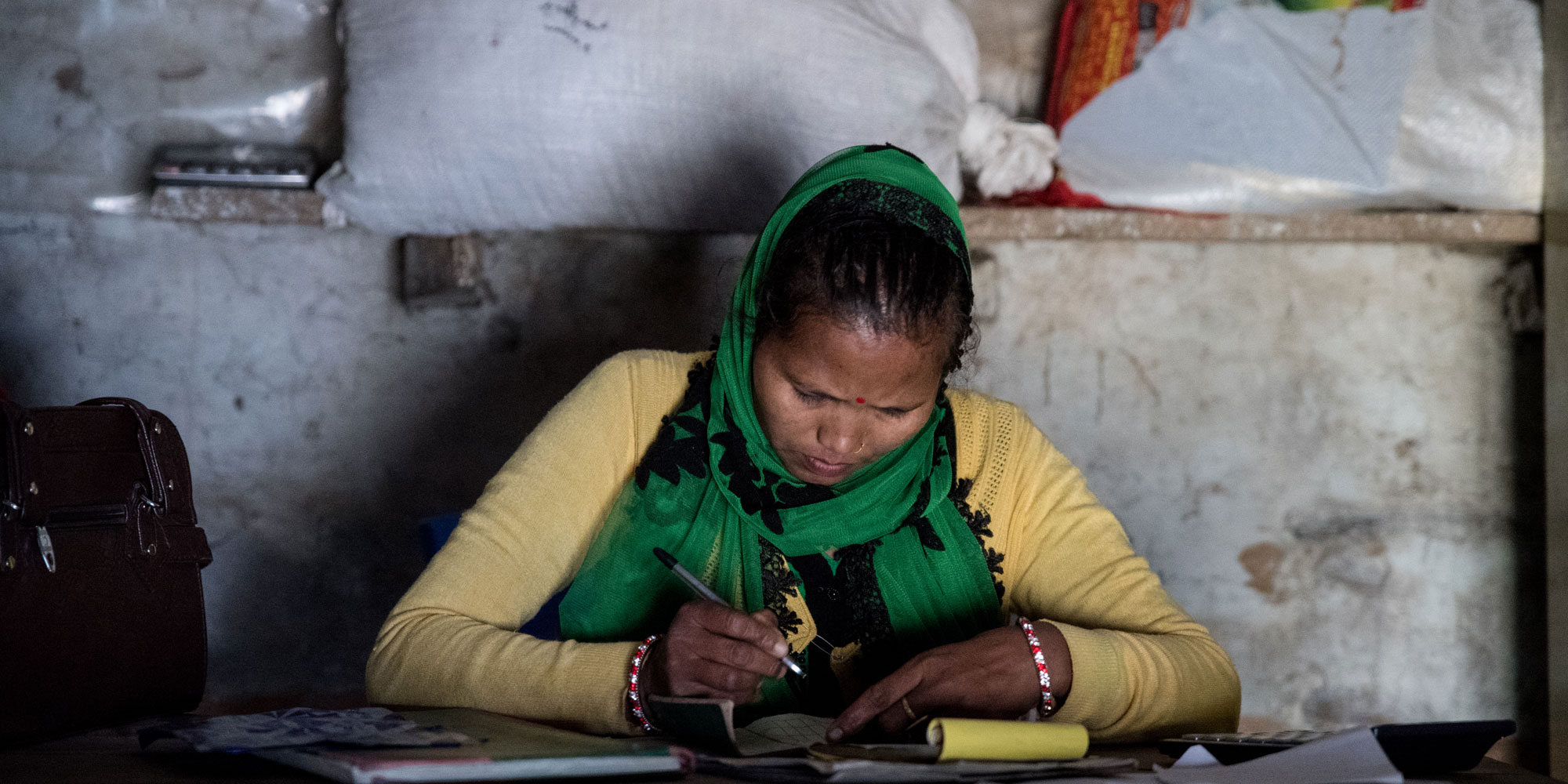 Nepalilainen nainen kirjoittaa kuittia. Kuva: Tuukka Ervasti