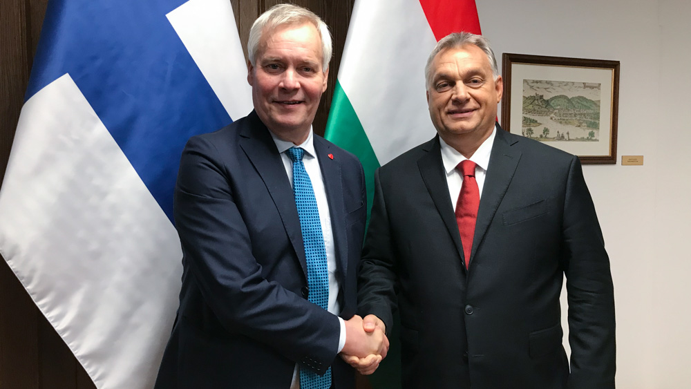 Pääministerit Antti Rinne ja Viktor Orbán kättelevät Suomen ja Unkarin lippujen edessä.