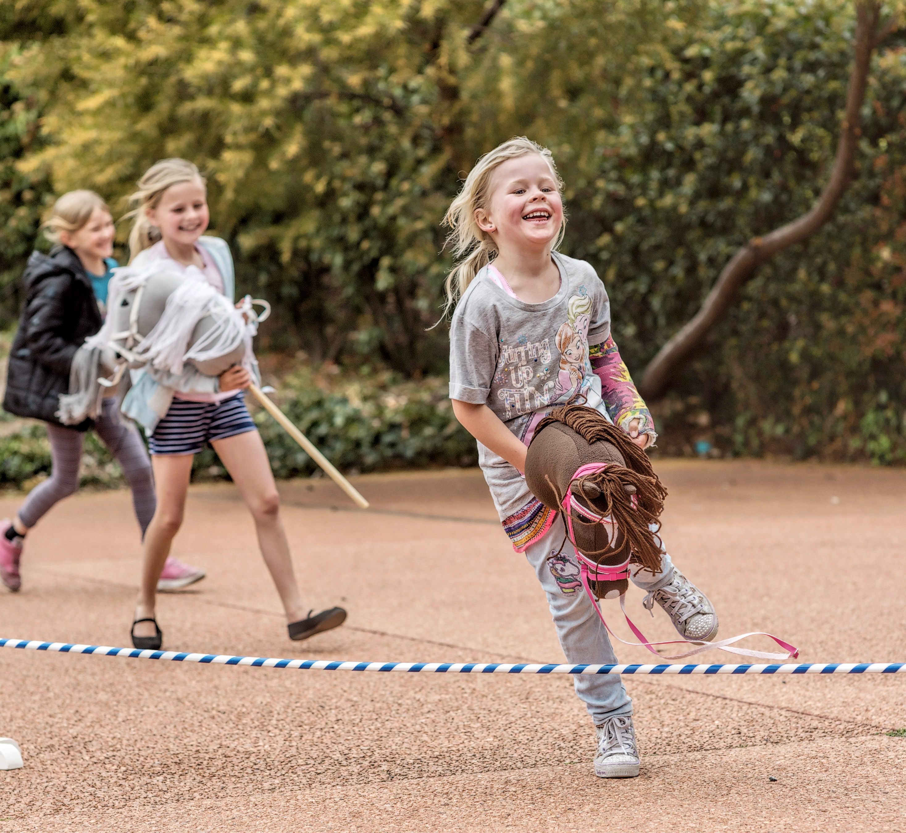 Children racing with their hobby horses.